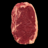 Black Angus rib steak van de voorkant op een zwarte achtergrond met duidelijke marmering en vetrand.