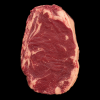 Black Angus rib steak vanuit een licht schuine hoek op een zwarte achtergrond met zichtbare marmering en dikke vetrand.